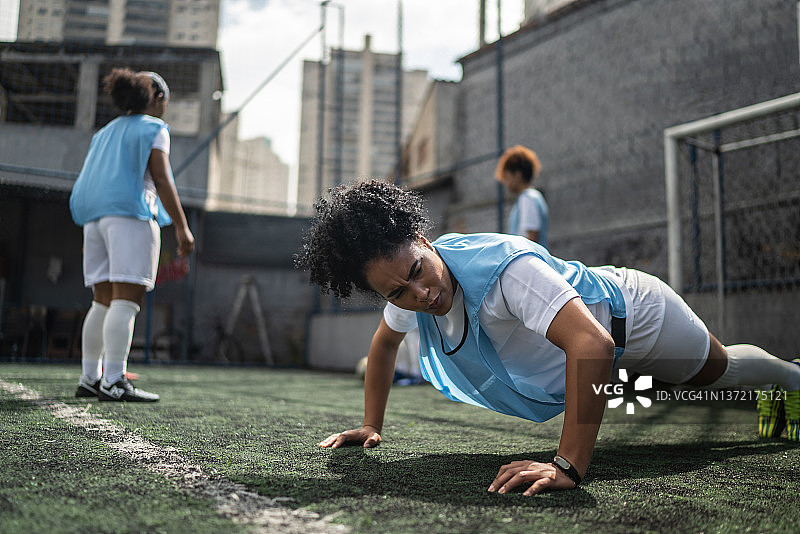 在训练中做俯卧撑的女足运动员图片素材