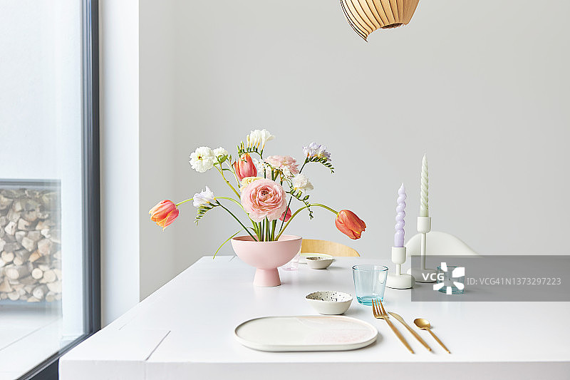 一个现代的春天花束小苍兰，毛茛和郁金香在一个漂亮的花瓶图片素材