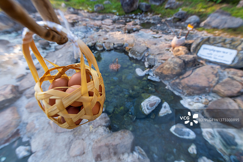 在泰国南邦采山国立公园的温泉里煮鸡蛋的游客们——早晨的天然矿泉水和大自然的美丽图片素材