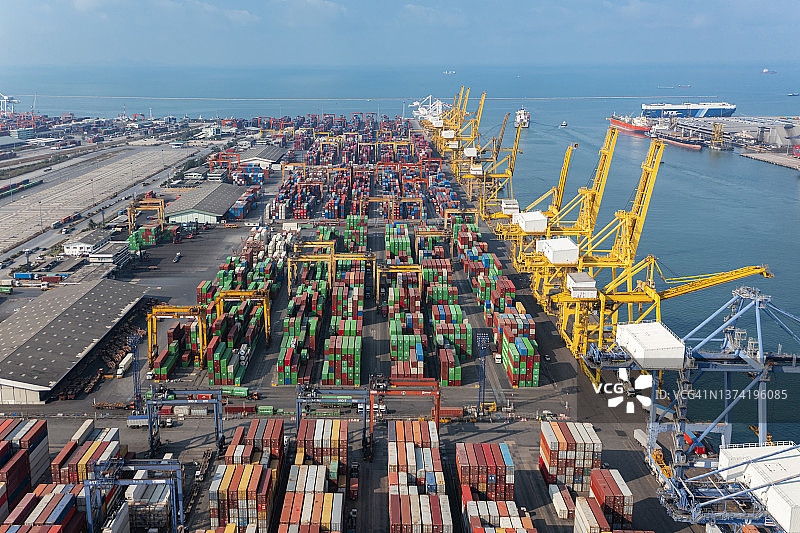 航拍集装箱船在海港或码头商港和工作起重机桥装集装箱的商业物流，进出口，航运或货运运输。图片素材