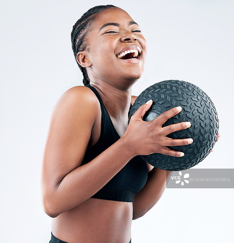 这张照片是一个运动的年轻女子在工作室背景下与一个实心球摆姿势图片素材