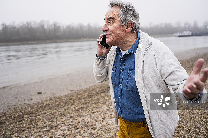 老人在海滩上用智能手机聊天图片素材