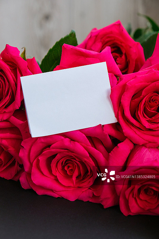 粉红色的玫瑰和白色的空纸笔记的文本复制空间。假期的模拟。情人节，母亲节。邀请贺卡图片素材
