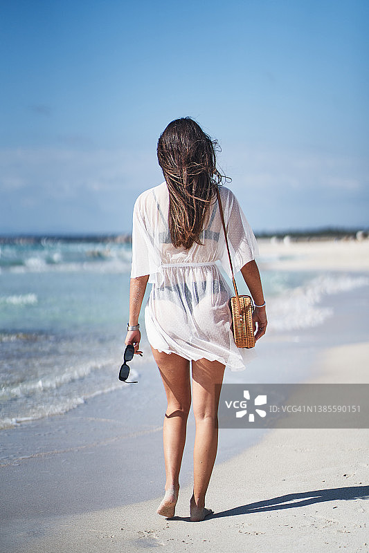 黑头发的女人在夏天海边散步图片素材