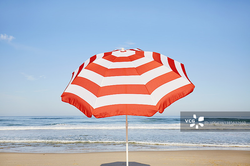沙滩上的条纹阳伞映衬着蓝天图片素材