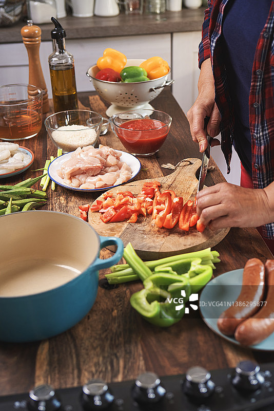 在铸铁锅中准备卡津风格的鸡肉，虾和香肠什锦饭图片素材