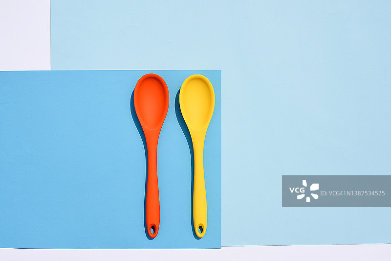 蓝色背景的彩色硅胶勺。烹饪的背景。烹饪弗拉。美食博客。餐具。图片素材