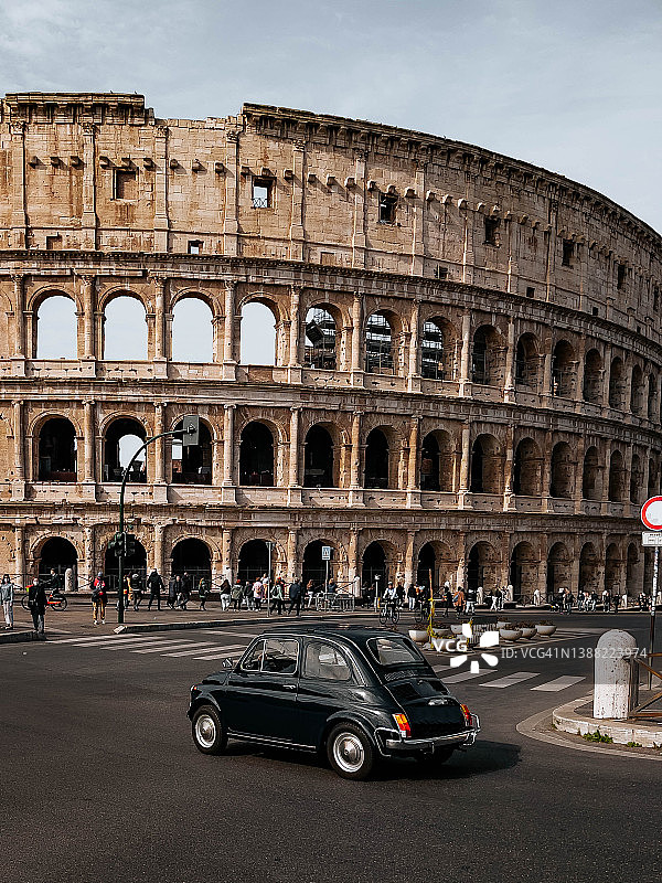 在罗马的圆形大剧场里，一辆充满田园气息的老爷车开在前面。图片素材
