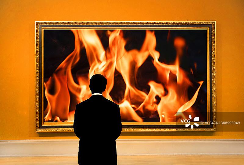 男子看着火焰的照片。图片素材