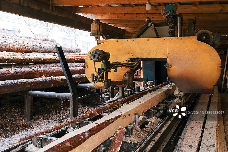 在锯木厂设备上锯木的过程。木材业图片素材