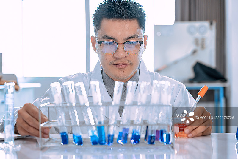 年轻的亚洲男子科学家在实验室工作的肖像。医生和科学家在实验室工作的冠状病毒大流行，covid - 19概念图片素材