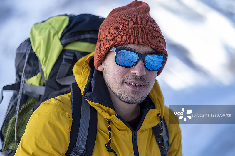 冬天背着背包在山里徒步旅行的人图片素材
