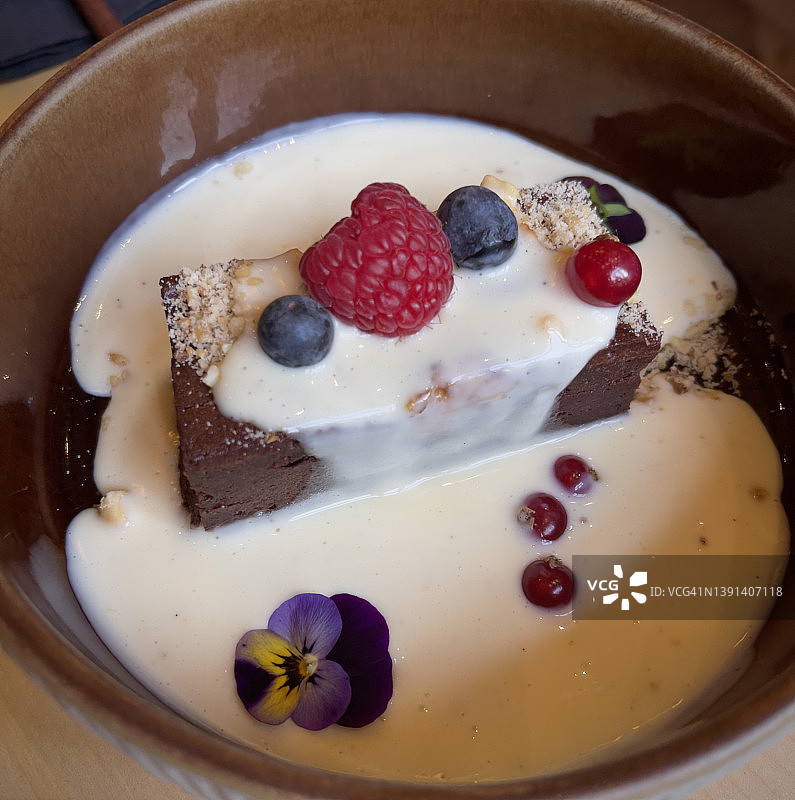 甜点布朗尼白奶油的特写，在桌子上的盘子里。图片素材