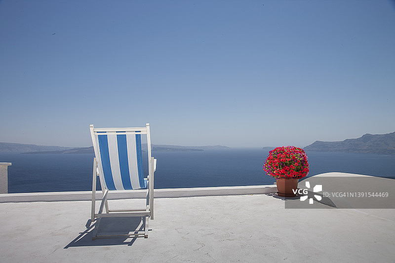 在希腊岛上的一个露台上的躺椅。图片素材