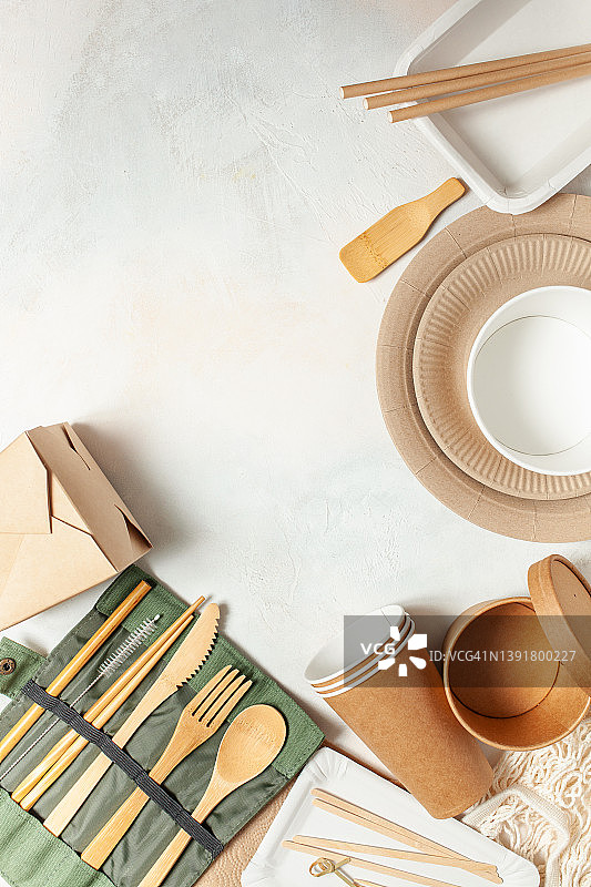生态牛皮纸餐具。纸杯，盘子，袋子，快餐容器和木制餐具在粉红色的背景。回收或零浪费的概念。前视图。本空间图片素材