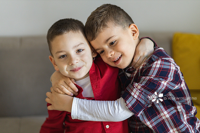两个微笑的男孩拥抱的肖像图片素材
