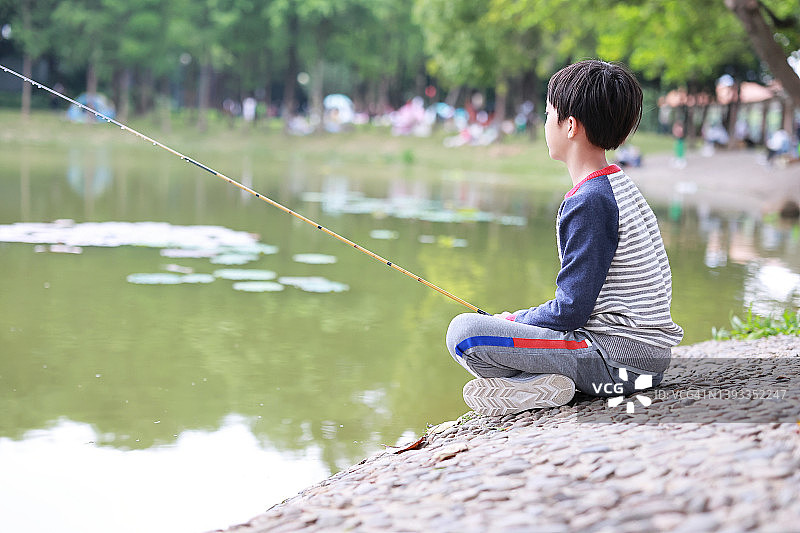 小男孩在户外钓鱼图片素材