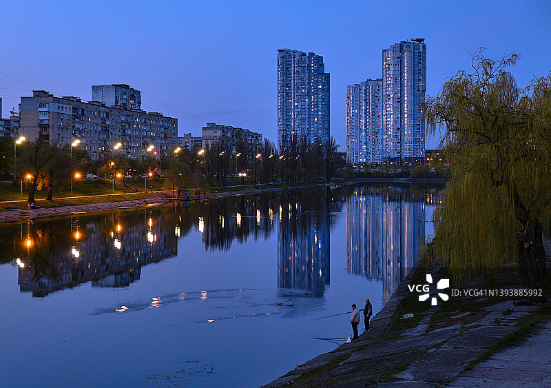 公园深夜河堤上的两名渔民图片素材