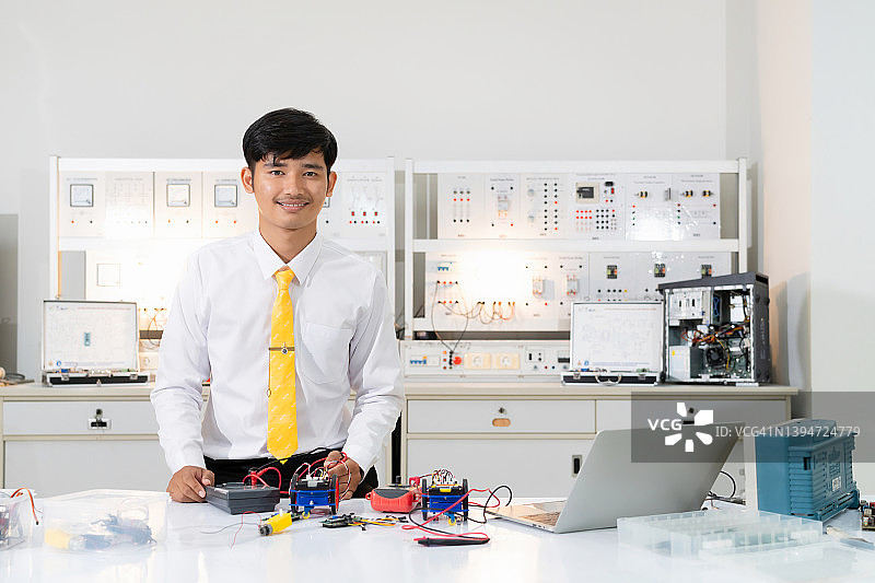 年轻的亚洲大学肖像学习机器人和电子板机器人与编程在计算机实验室的科学教室图片素材