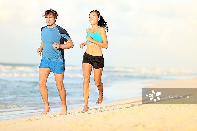 情侣在沙滩上跑步图片素材