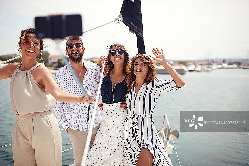 一群年轻英俊的模特在海边的游艇甲板上自拍。夏天，大海，假期，友情图片素材