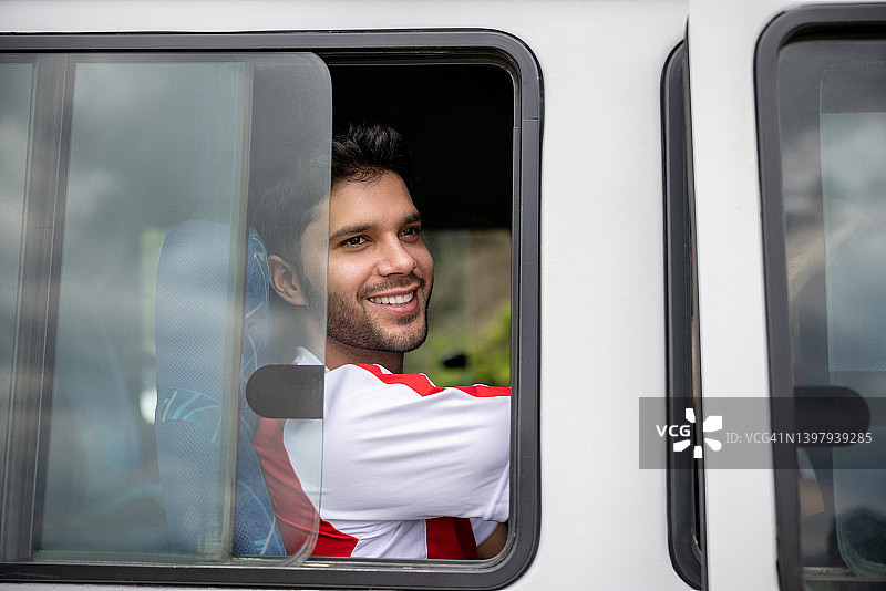 快乐的足球运动员乘坐公共汽车去足球训练图片素材