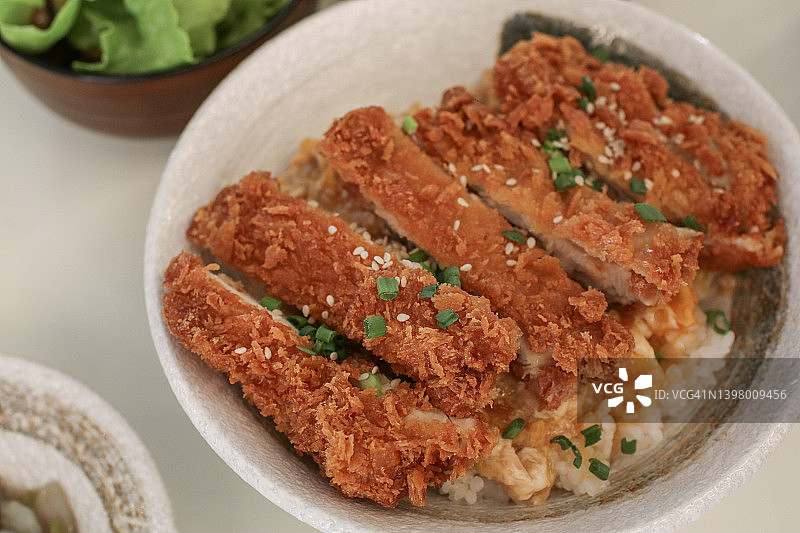 猪排或脆炸鸡配日本饭。多汁的鸡肉装饰在简单的概念。图片素材