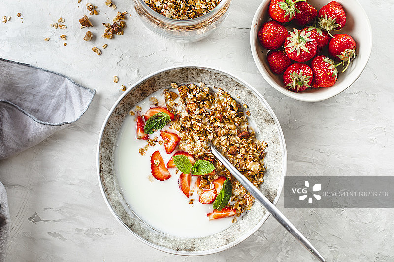 健康生活方式的早餐食品概念。自制麦片，浆果和酸奶放在碗里。俯视图，平面布局图片素材