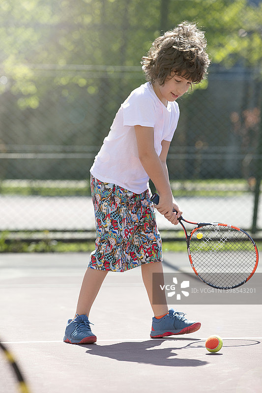 欢快的孩子们在球场上打网球图片素材