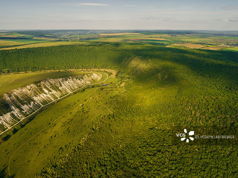 在夏天的时候，无人机从上面拍摄的美丽的绿色山丘的照片。图片素材