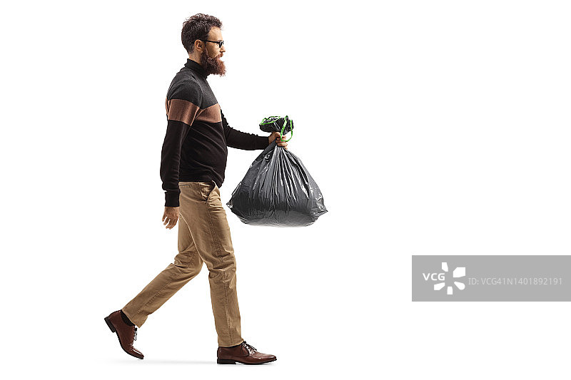 一名大胡子男子背着一个塑料垃圾袋走路的完整的侧面照片图片素材