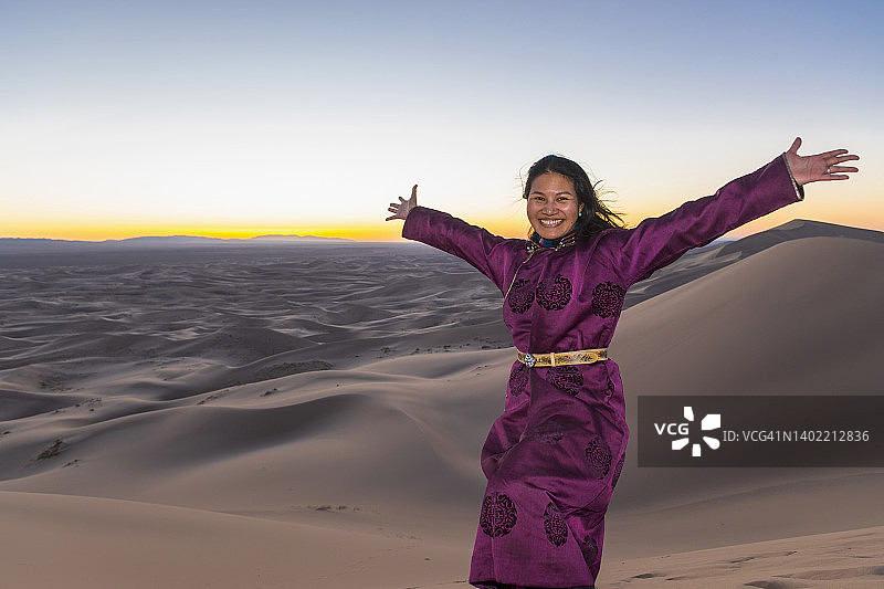 在戈壁沙漠大沙丘上摆姿势的女人图片素材