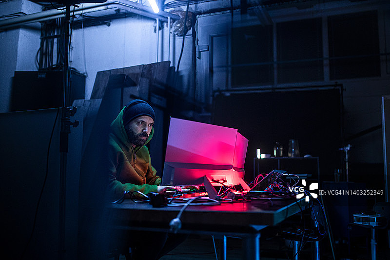 黑客在暗室里操作电脑。图片素材