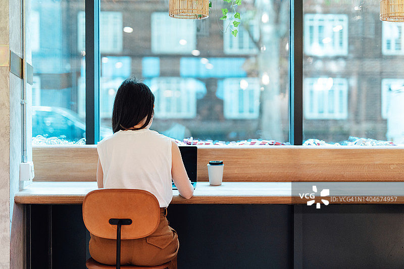 年轻的亚洲女性使用笔记本电脑在联合办公空间工作图片素材