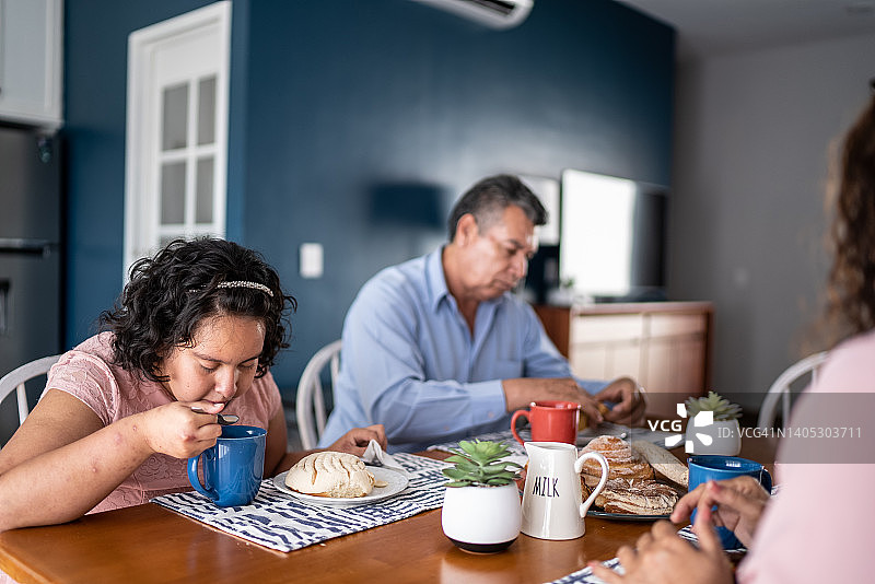 一家人在家里吃早餐——包括一个精神运动迟缓的女孩图片素材