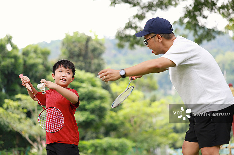 父子俩在公园里打羽毛球图片素材