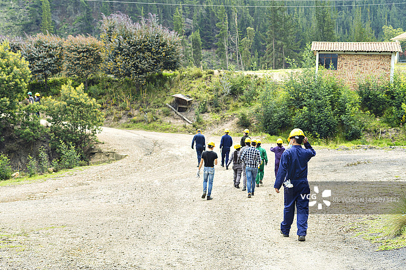 一群矿工沿着小路行走。图片素材