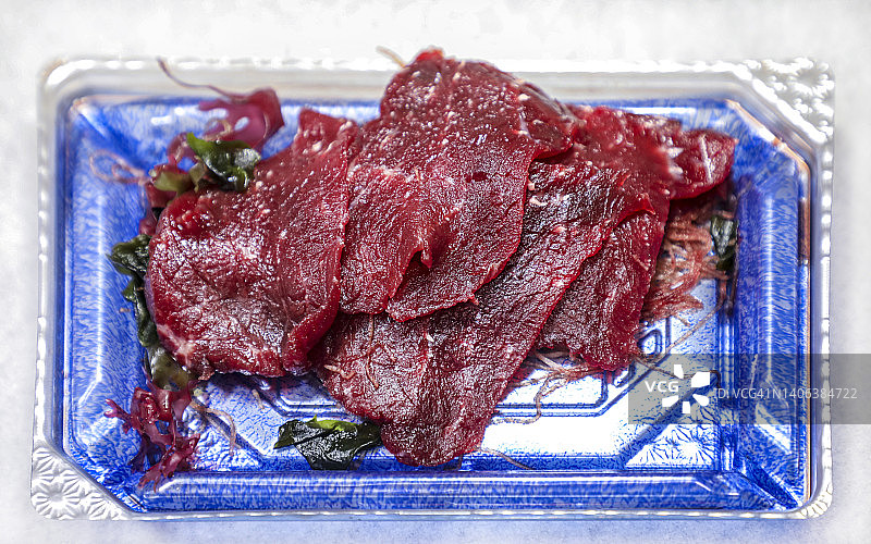 切片的鲸鱼肉在塑料托盘图片素材
