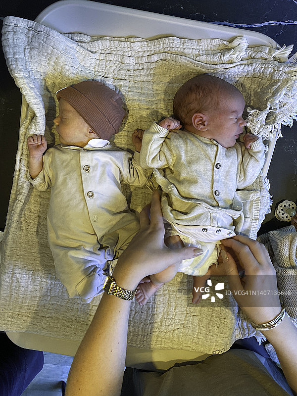 妈妈给刚出生的双胞胎换尿布图片素材