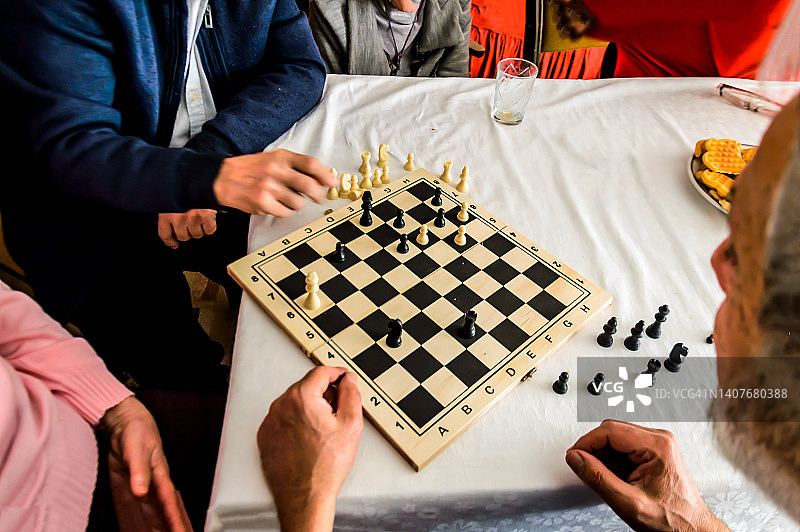 在一次社交聚会上，一群长辈在下棋，玩得很开心。图片素材