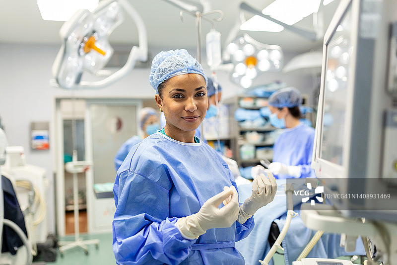 一名年轻的女医生在手术前戴着防护面罩准备麻醉机的肖像图片素材