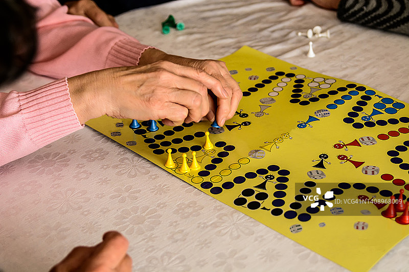 在社交会议上，年长的参与者玩ludo游戏玩得很开心。图片素材