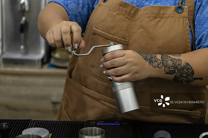 女人用咖啡研磨机准备咖啡图片素材