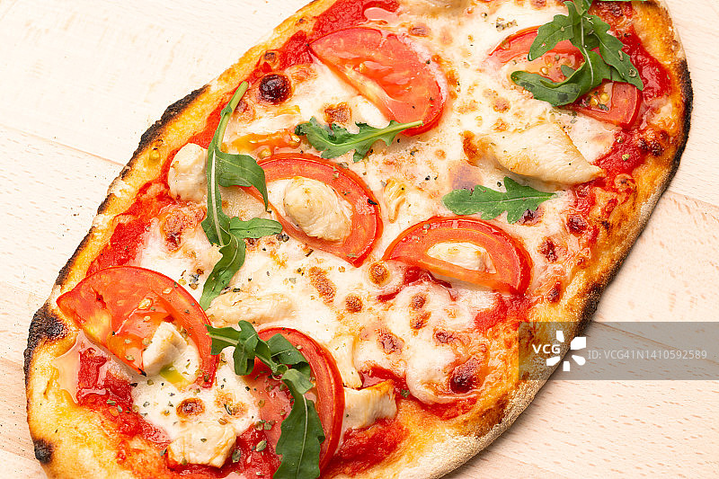 美味的披萨装在木盘子里。概念广告传单和海报的餐厅或披萨店，模板与美味的意大利辣香肠的味道。图片素材