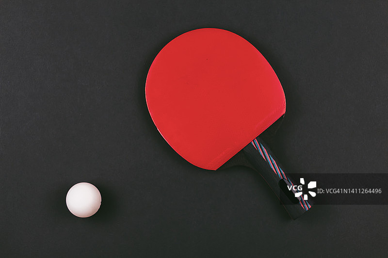 乒乓球拍和球在黑色背景。图片素材