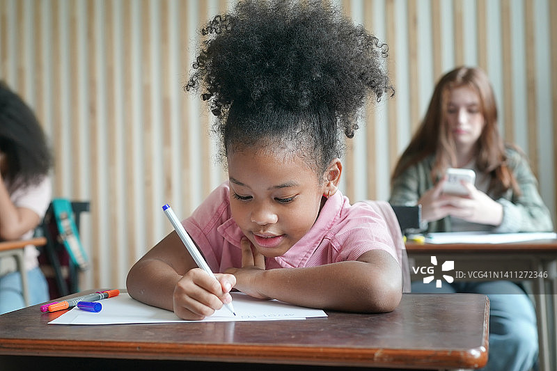 非洲孩子们在教室画画和做作业，小女孩在学校快乐有趣的学习图片素材