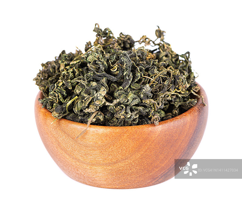 干燥绞股蓝叶在木碗里，离生在白色黑土上。焦谷兰或奇迹草。中国花草茶。图片素材