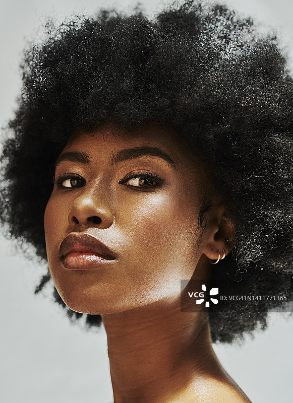 肖像自信的黑人妇女与自然头发在一个时髦的爆炸头，孤立的工作室背景。强大的
黑人女性看起来光彩照人，性感，只化妆和态度图片素材