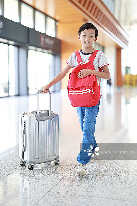 带着行李箱的男孩在机场，图片素材