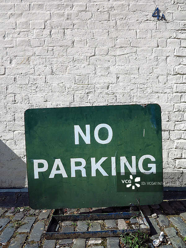 在英国伦敦的一堵白墙前的老街道禁止停车标志的特写图片素材